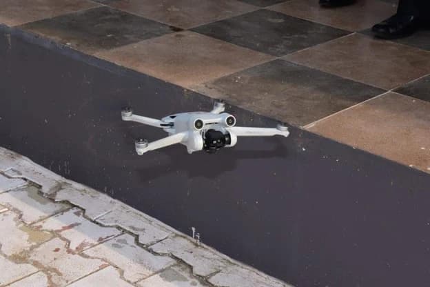 A CISS drone flying at low level over a tiled courtyard.